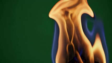 Poster - Close-up of orange flame with green background, abstract shape. Energy and nature concept