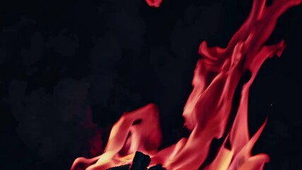 Poster - Vivid red and orange flames flickering in darkness with wood embers glowing, dynamic energy scene. Fire and warmth concept