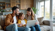 © redtiger9 - Happy Family Homeowners Watching Laptop on Couch in Cozy Modern Apartment