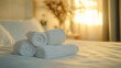 © Tahsin - Fluffy towels stacked neatly on a hotel bed convey a welcoming atmosphere