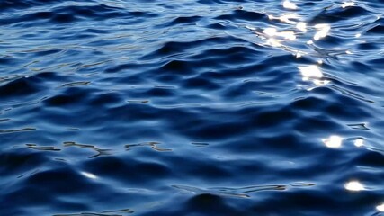Poster - Close-up of sunlight reflecting on dark blue ocean waves, serene and peaceful seascape. Nature and tranquility concept
