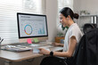 © David - Young business finance market analyst in eyeglasses working at office  .Business woman analyze document Graphs and diagramm on Desktop Computer screen.