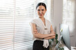 © David - Arms crossed Happy enterpriser asian woman looking at camera and smile while crossing arm isolated on pastel office background.