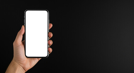 Poster - Smartphone mockup in hand holding mobile device. Hand holding smartphone mockup with blank screen on black background. Mobile device in hand