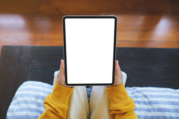 Wall Mural - Top view mockup image of a woman holding tablet with blank desktop white screen at home