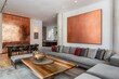 © HO - A chic loft interior with a stylish grey sofa, a large rose gold abstract painting on the wall, and a sleek wooden coffee table, elegant and modern