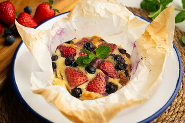 Wall Mural - Delicious sweet clafoutis tart with blueberries and strawberries baked using a traditional French recipe.