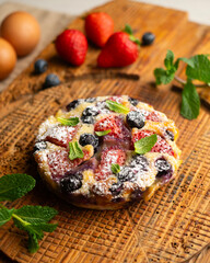 Wall Mural - Delicious sweet clafoutis tart with blueberries and strawberries baked using a traditional French recipe.