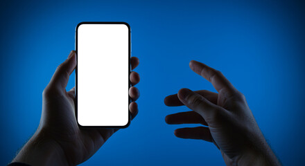 Poster - Smartphone in hand with blank screen against blue background. Hands holding smartphone with blank screen for mockup. Smartphone held in hands