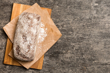 Wall Mural - Freshly baked bread on cutting board against white wooden background. top view bread with copy space