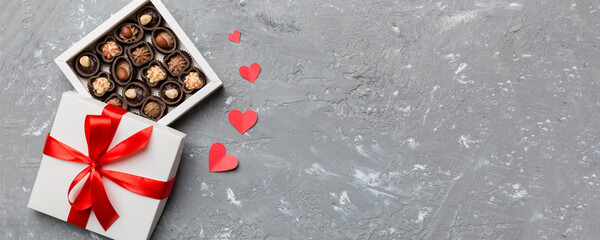 Wall Mural - Delicious chocolate pralines in red box for Valentine's Day. Heart shaped box of chocolates top view with copy space