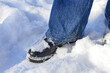 © Виталина Митрофанова - winter-themed close-up person standing in the snow blue jeans black shoes snow sticking to the shoes winter fashion footwear activities walking outdoor adventures resilience travel cold seasonal legs