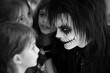 © ChaoticMind - Children interacting with a person in unique makeup during a festive event at an indoor location