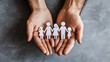© Alina Tymofieieva - Family bond represented through cut-out figures held in hands, symbolizing unity and connection among individuals