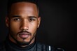 © c80 - Portrait of a confident man in a black racing suit against a dark background showcasing determination and focus