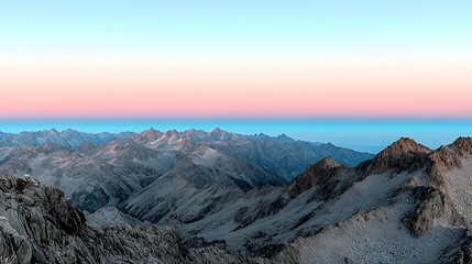 Wall Mural - A breathtaking view of rugged mountains under a pastel sky, showcasing a serene landscape at dusk with a blend of colors stretching across the horizon.