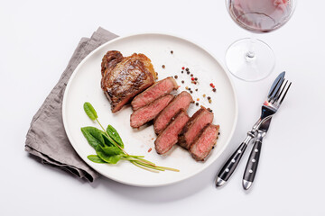 Poster - A perfectly cooked sliced striploin steak with a juicy, tender texture, served alongside a glass of rich red wine