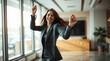 © hurricanehank - Cheerful lawyer celebrates victory in a law firm office. Happy business female dancing after successful deal.