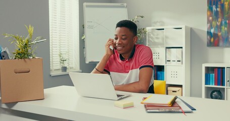 Wall Mural - Thoughtful boy makes a phone call gets super information enjoys winning a prize, cash injection, raises his hand with palm clenched into a fist, gesturing, dancing, smiles widely, happiness