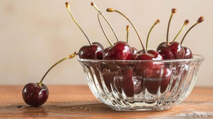 Poster - A bowl filled with ripe cherries on a wooden surface, showcasing their vibrant color and freshness.