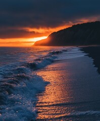 Canvas Print - A vivid sunset paints the sky over the ocean, as waves rhythmically crash against the sandy shore, creating a serene coastal scene.