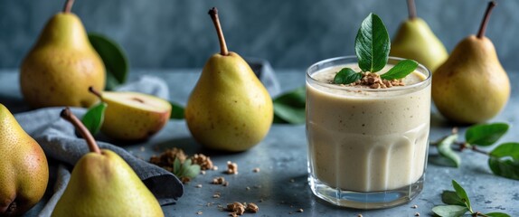 Wall Mural - Pear smoothie in glass cup garnished with green leaves surrounded by fresh pears and grey cloth on textured background