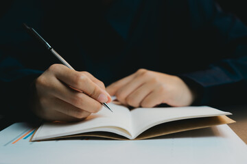 Poster - Hand Writing Notes in Blank Notebook with Pen on Dark Background