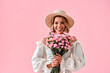 © HBS - Happy women's day. Beautiful young woman with bouquet of pink carnations on soft pink background. International women's Day celebration.