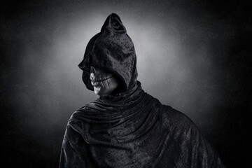 Wall Mural - Scary figure with hooded cloak over dark misty background with clipping path