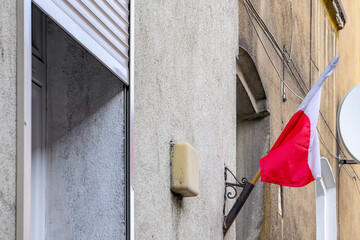 Wall Mural - white and red Polish flag. national flag hanging on a residential building during a national holiday.