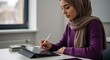 © Natsumae - Focused young woman in hijab uses tablet, studying diligently.  Serene atmosphere, academic pursuit.