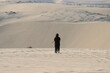 © Catalin - Woman in black walking on sand in an empty desert