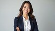 Portrait of young asian businesswoman isolated on white background. Confident successful woman in business suit with arms folded looks at camera with friendly smile. Leadership concept.