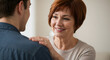 © bastet - Supportive older woman smiling and comforting a young man