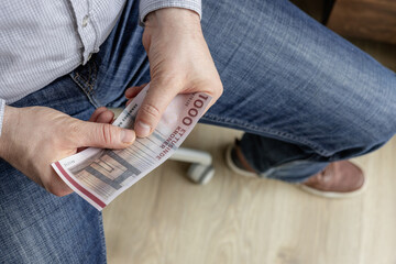 Wall Mural - Denmark money. Businessman holding a 1000 Danish kroner banknote in his hands. Financial business concept. Withdrawal from circulation of the thousand kroner banknote by the Danes