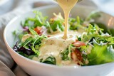 Drizzling creamy salad dressing on fresh greens kitchen food photography bright close-up