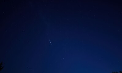 Wall Mural - Starry night sky with satellite streak