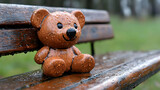 Rainy day, teddy bear park bench, wet wood, green background, childhood memories