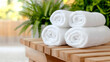 © MAKASIHMAS SIDNEY - Spa towels on wooden bench, plants background, relaxation