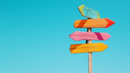 Poster - Four colorful wooden arrows pointing in different directions on a wooden pole represent the concept of choice, decision making, and finding the right path against a clear blue sky