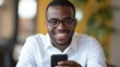 © Olena - Beautiful businessman with glasses smiling while filling out an online survey on his mobile phone.