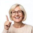 © EddieSnapix - A cheerful woman with glasses expresses happiness by smiling and pointing her finger, suggesting excitement or sharing important information in a well-lit indoor setting