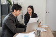 © wichayada - Team members analyzing financial reports together in a contemporary office space.