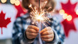 © Sergey - Celebration and joy as young hands embrace a sparkler on canada day