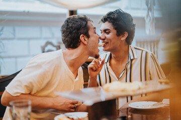 Wall Mural - Two young men enjoy a playful and joyful moment while sharing food at a dining table, exuding friendship and happiness.