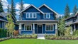 © Sulton - Photo of a navy blue Craftsman-style home in Vancouver, British Columbia, with green grass and trees in the front yard. The home has white trim on the windows. The shot is taken from street level, sho