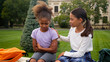 © Yuliia - African Latina pupils primary school education little girls teen students schoolgirls studying children kids sad upset offended worried conflict sorry friend calm help support friendship city outdoors