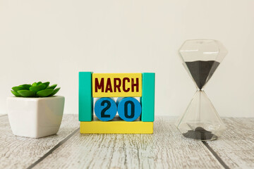 Wall Mural - Wooden block calendar with date March 20 in the hand of puppet