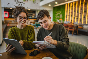 Wall Mural - couple learn together and prepare exam on digital tablet at cafe