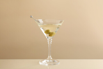 Wall Mural - Martini cocktail with olives in glass on beige table